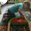 Clement joue avec le premier train de voyage de BRIO